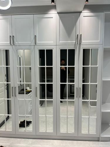 a person taking a picture in a white closet at Qarb Apartment Dernegul metro in Baku