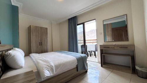 a bedroom with a bed and a dresser and a mirror at Mariam Economy Hotel in Aqaba