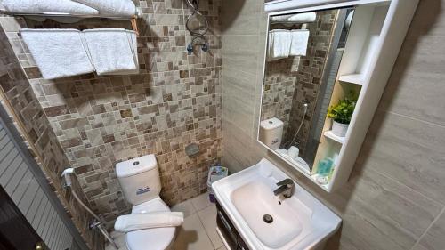 a bathroom with a toilet and a sink and a mirror at Mariam Economy Hotel in Aqaba