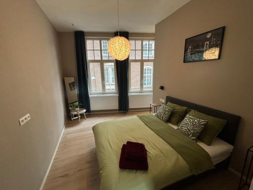 a bedroom with a bed and a chandelier at Apartment central Lier in Lier