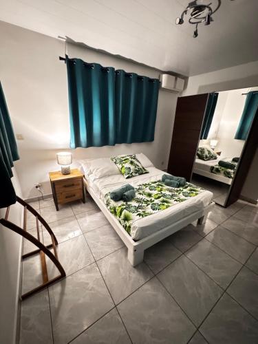 a bedroom with a bed and a blue curtain at Maeva I Papara in Papara