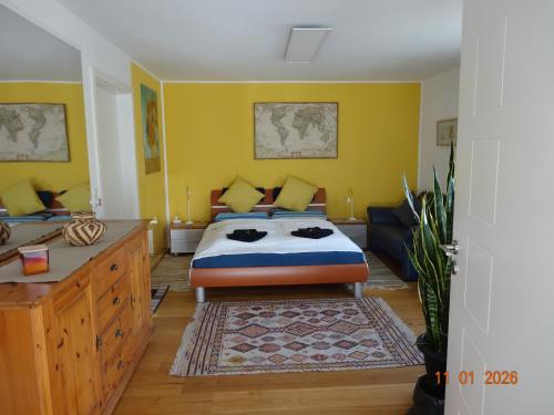 a bedroom with yellow walls and a bed and a rug at Kleine Einliegerwohnung- komfort Home! in Lahnau