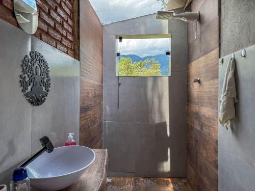 a bathroom with a white sink and a window at Chalé Agulhas Negras in Resende