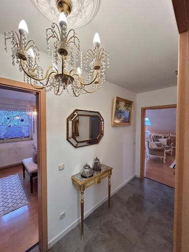 a living room with a chandelier and a table at Vintage Traum in Hückelhoven