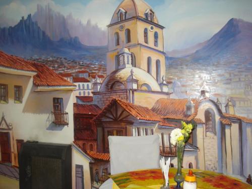 a table with a vase of flowers and a painting at Isabela Hotel Suite in La Paz