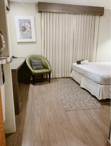 a bedroom with a bed and a desk and a chair at STOP Mar Suite Privada - NI in Nova Iguaçu
