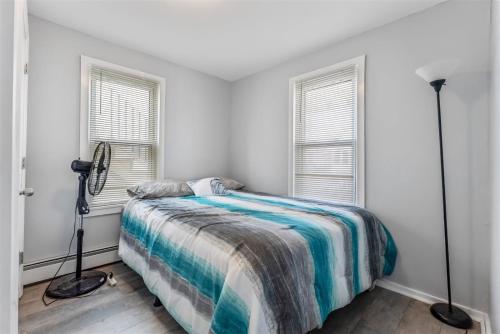 a bedroom with a bed and two windows at 404 W Maple Ave, Unit A in Wildwood