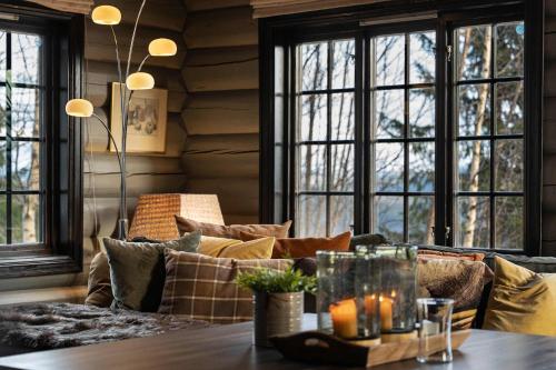 a living room with a couch and windows at TH590- Large ski-in out chalet with jacuzzi, sauna in Trysil in Trysil