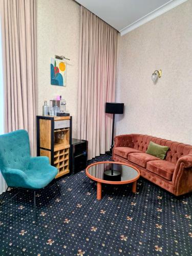 a living room with a couch and a chair at Arts Hotel by Square in Tbilisi City