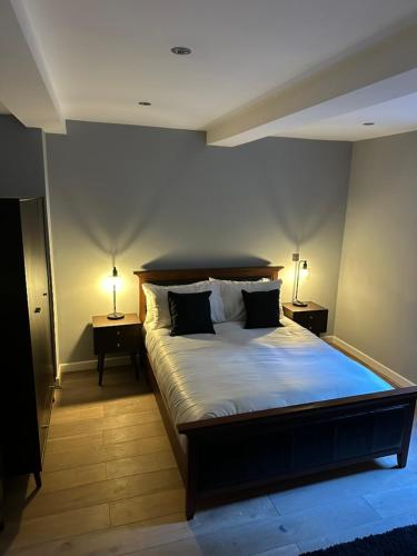 a bedroom with a large bed with two lamps on tables at Riverview Apartment 2 in Matlock