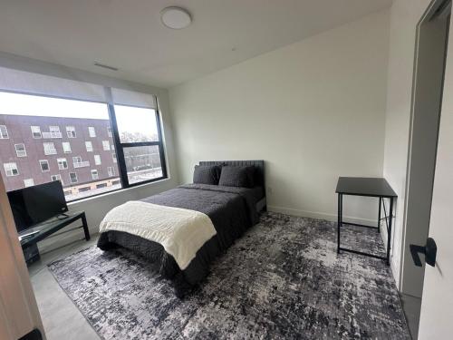 a bedroom with a bed and a large window at Modern Downtown Detroit 2BR Retreat in Detroit