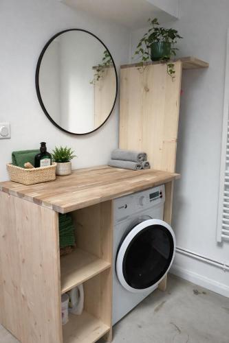 a washing machine under a wooden counter with a mirror at L'Atelier Saint Michel in Bordeaux