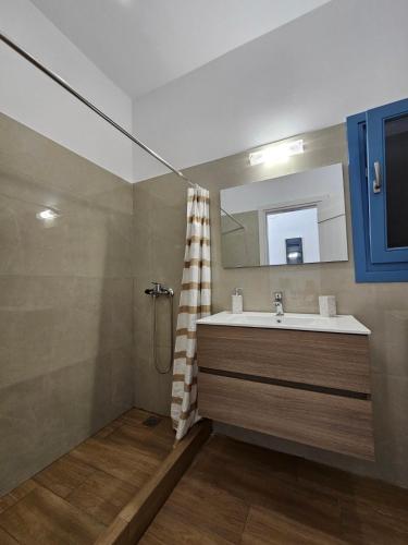 a bathroom with a sink and a mirror at Aspalathos I & ΙΙ in Kamárion