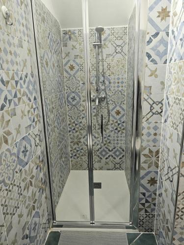 a shower with blue and white tiles in a bathroom at Casa Vacanze AFEA Torre dell'Orso Salento Puglia in Torre dell'Orso