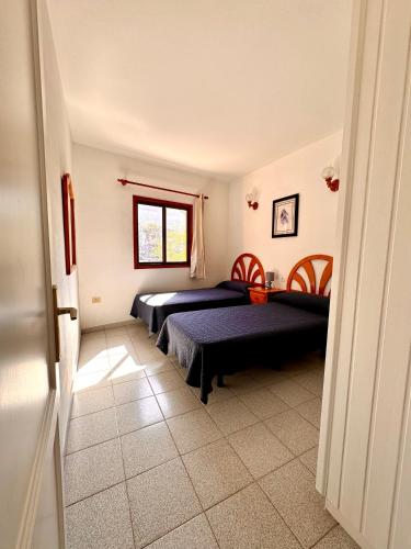 a bedroom with two beds and a window at Mangos Mar E in Puerto Naos