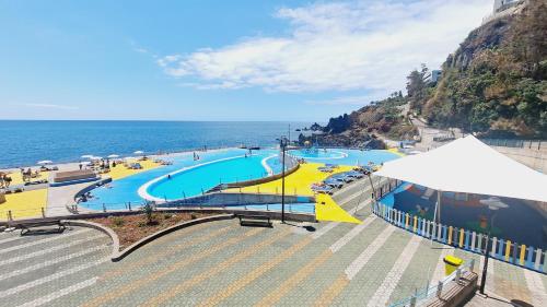 a large swimming pool next to the ocean at Chalé Funchal - City view in Funchal