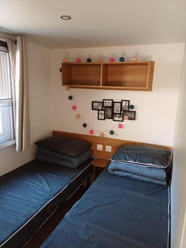 a bedroom with two beds and a shelf and a window at Le ptit Galet 462 in La Tremblade