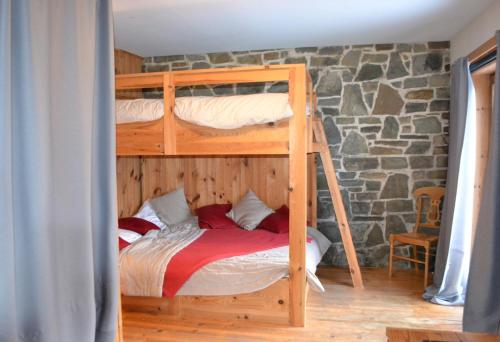 a bedroom with two bunk beds and a stone wall at Les Grosses Pierres à Spa in Spa