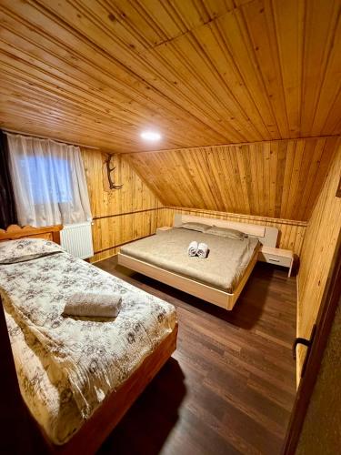 a bedroom with two beds in a wooden room at Cabana SVA Bilbor in Bilbor