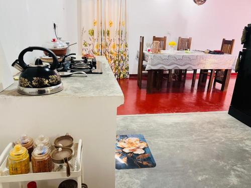 a kitchen with a stove and a dining room at Liyos House in Matara