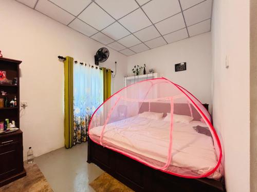 a bedroom with a bed with a pink canopy at Liyos House in Matara