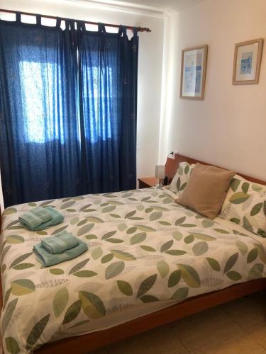 a bedroom with a large bed with blue curtains at Vicente Buades in Port de Pollensa
