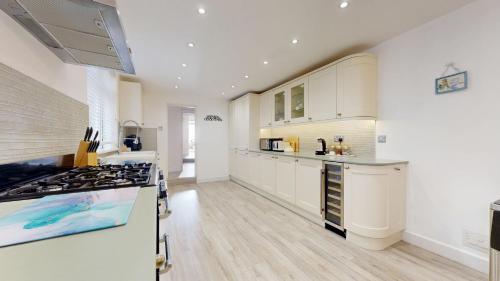 a kitchen with white cabinets and a stove top oven at Seasons in Weymouth