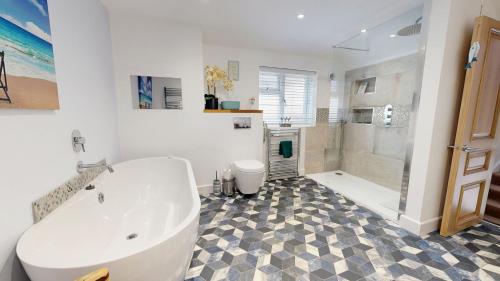 a white bathroom with a tub and a shower at Seasons in Weymouth