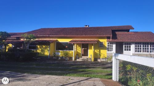 a yellow house with a fence in front of it at Fazenda Vista Soberba in Nova Friburgo