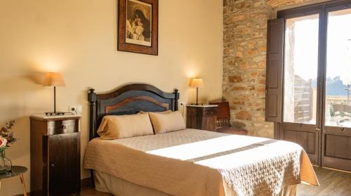 a bedroom with a bed and a brick wall at La Torre del Vilar in Santa Eulalia de Ríuprimer