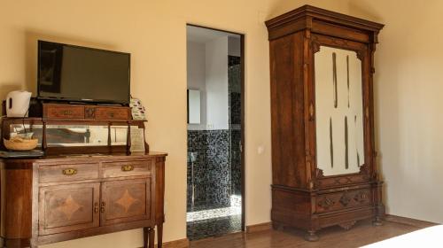 a room with a tv and a dresser with a tvictericter at La Torre del Vilar in Santa Eulalia de Ríuprimer