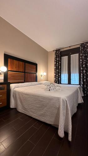a bedroom with a large bed with a white blanket at H Nieves Playa in Chipiona