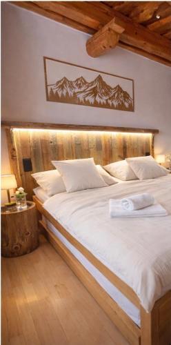 a bedroom with a large bed with a wooden headboard at Apartmány Starý mlyn in Habovka