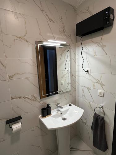 a bathroom with a sink and a mirror at Beachfront Apartment in Assilah, Private Solarium, 4 Pools, Secure Residence, WiFi, Parking in Asilah