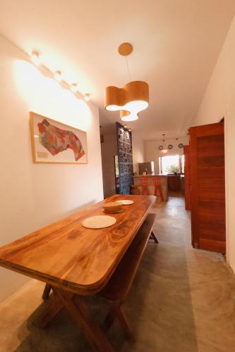 a dining room with a wooden table in a room at Casa Passarela in Icapuí
