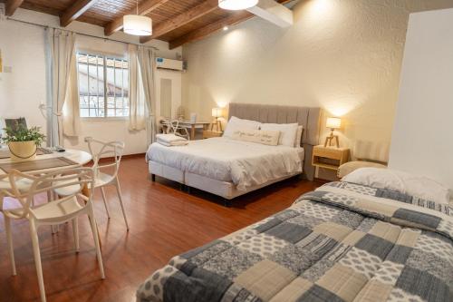 a bedroom with two beds and a table and a desk at "Casa Amalia Apartamentos" Plaza Italia y Arístides a media cuadra, Ubicación Exclusiva Top in Mendoza