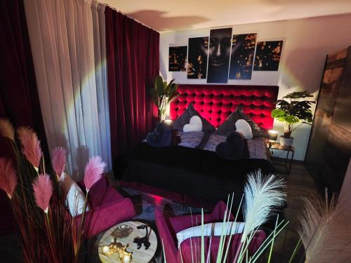 ein Schlafzimmer mit einem Bett mit rotem Kopfteil in der Unterkunft Mefady Ferienhaus Stadtkyll in Stadtkyll