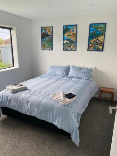 a bedroom with a large bed with blue sheets at Pukutahi Palms in Te Anau