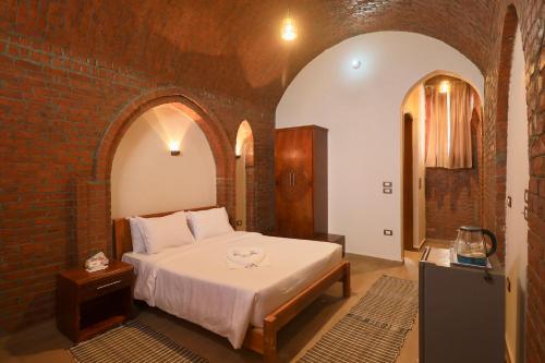 a bedroom with a bed in a brick wall at Golden Land in ‘Ezbet Abu Ḥabashi