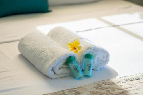 a towel and two tubes of toothpaste and a flower at Holiblue in Blue Bay