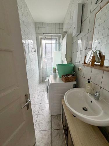 a white bathroom with a sink and a mirror at Stilvolle Wohnung mit Rheinblick in Weißenthurm
