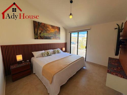 a bedroom with a large bed and a large window at AdyHouse Ziré in Buena Vista