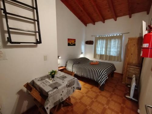 a room with two beds and a table in it at La Serena Cabañas in Potrero de los Funes
