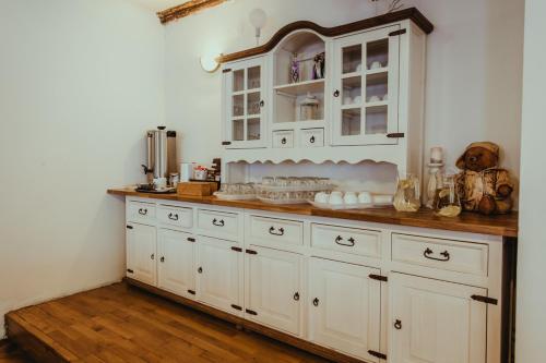 a large kitchen with white cabinets and wooden floors at Anna in Miłków