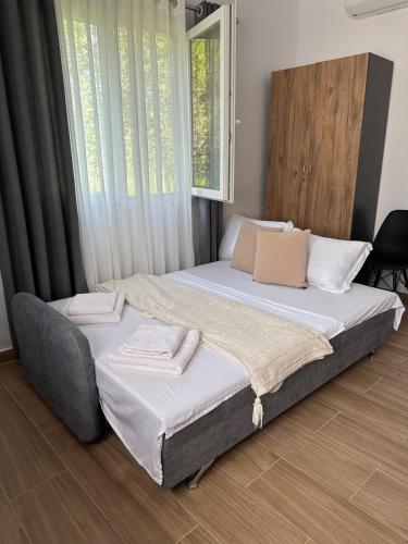 a large bed in a room with a window at Lexhulo Room's in Domje