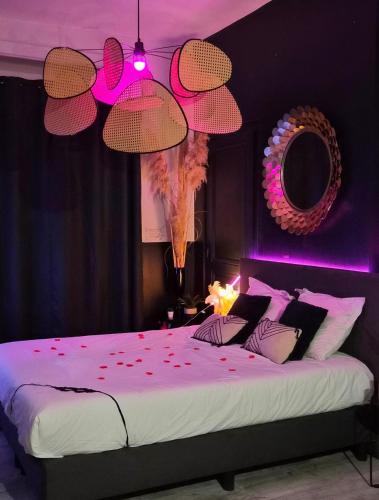 a bedroom with a large bed with red petals on it at Suite Passion - Jacuzzi privé - Table massage in Saint-Étienne