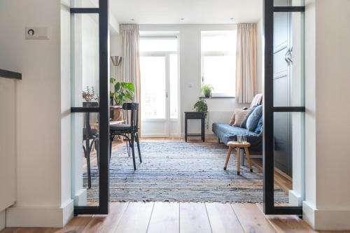 a living room with a mirror and a blue couch at Gorgeous And Stylish Place For Two In Hip West! in Amsterdam