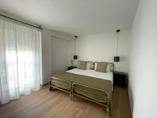 a bedroom with a bed and a large window at Entre Murallas in Doña Mencía
