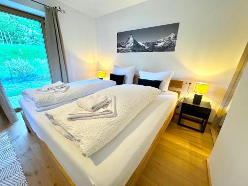 a bedroom with two beds and a large window at Ferienhaus "Bodenschneid" am Schliersee in Schliersee