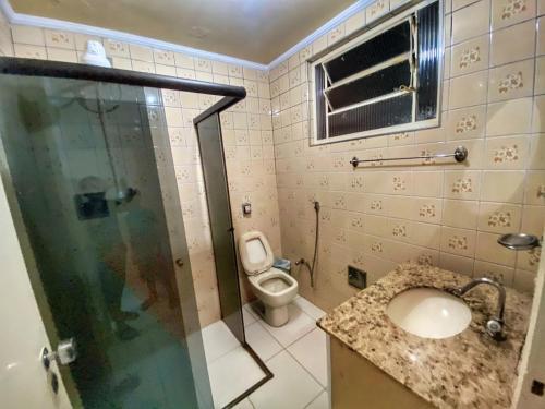 a bathroom with a toilet and a sink and a shower at Casarão Hostel in Guaratinguetá